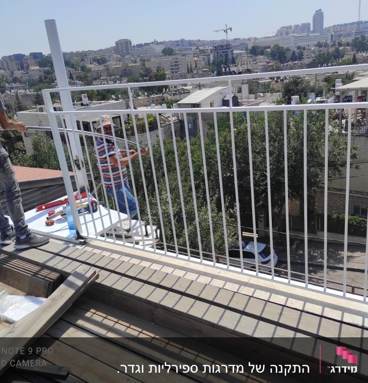 שני אנשים מתקינים מסגרת מתכת על גג